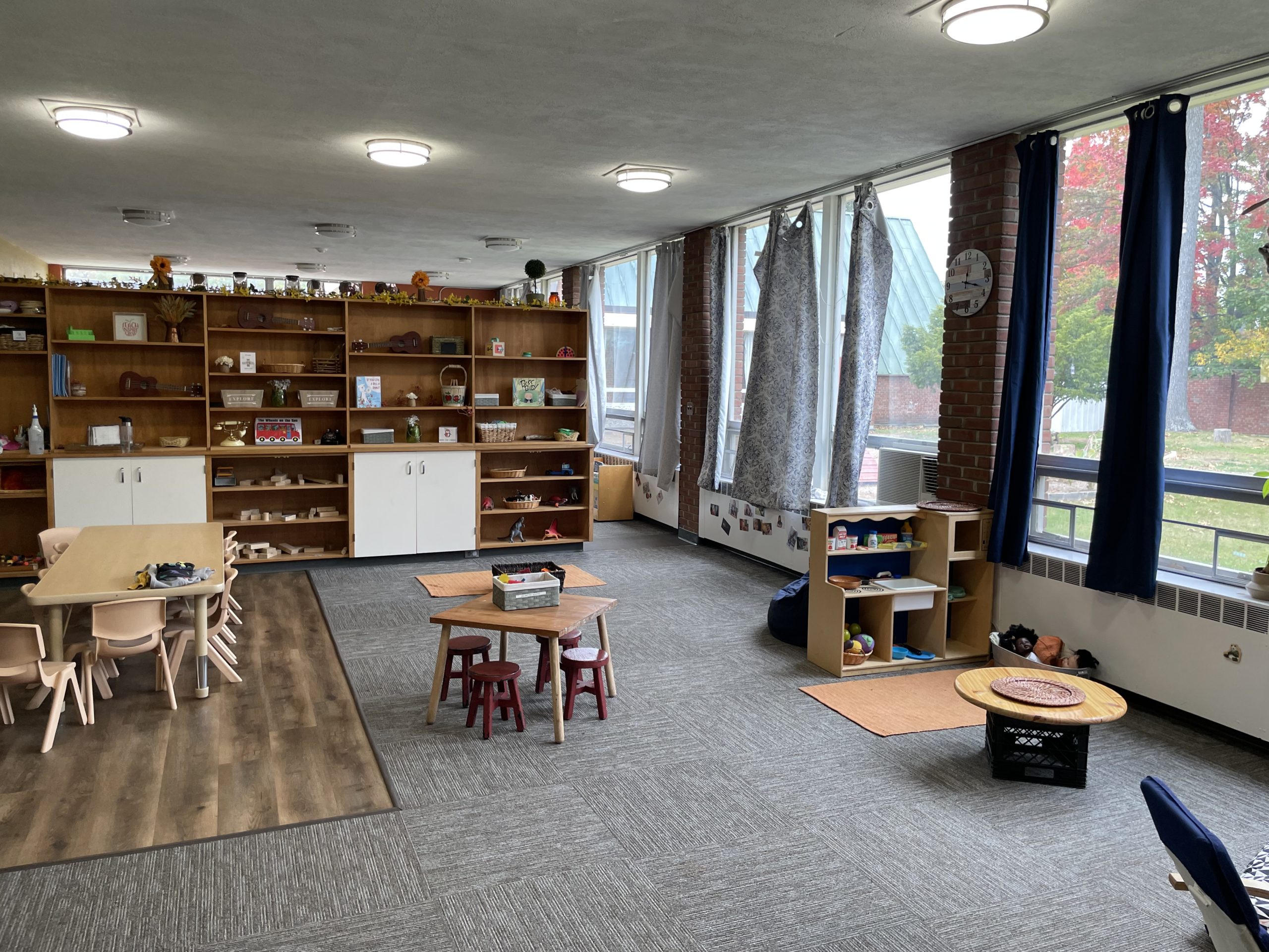A large children's classroom featuring windows along a long wall that give a view of the courtyard of an educational property for rent in Burlington, Vermont.